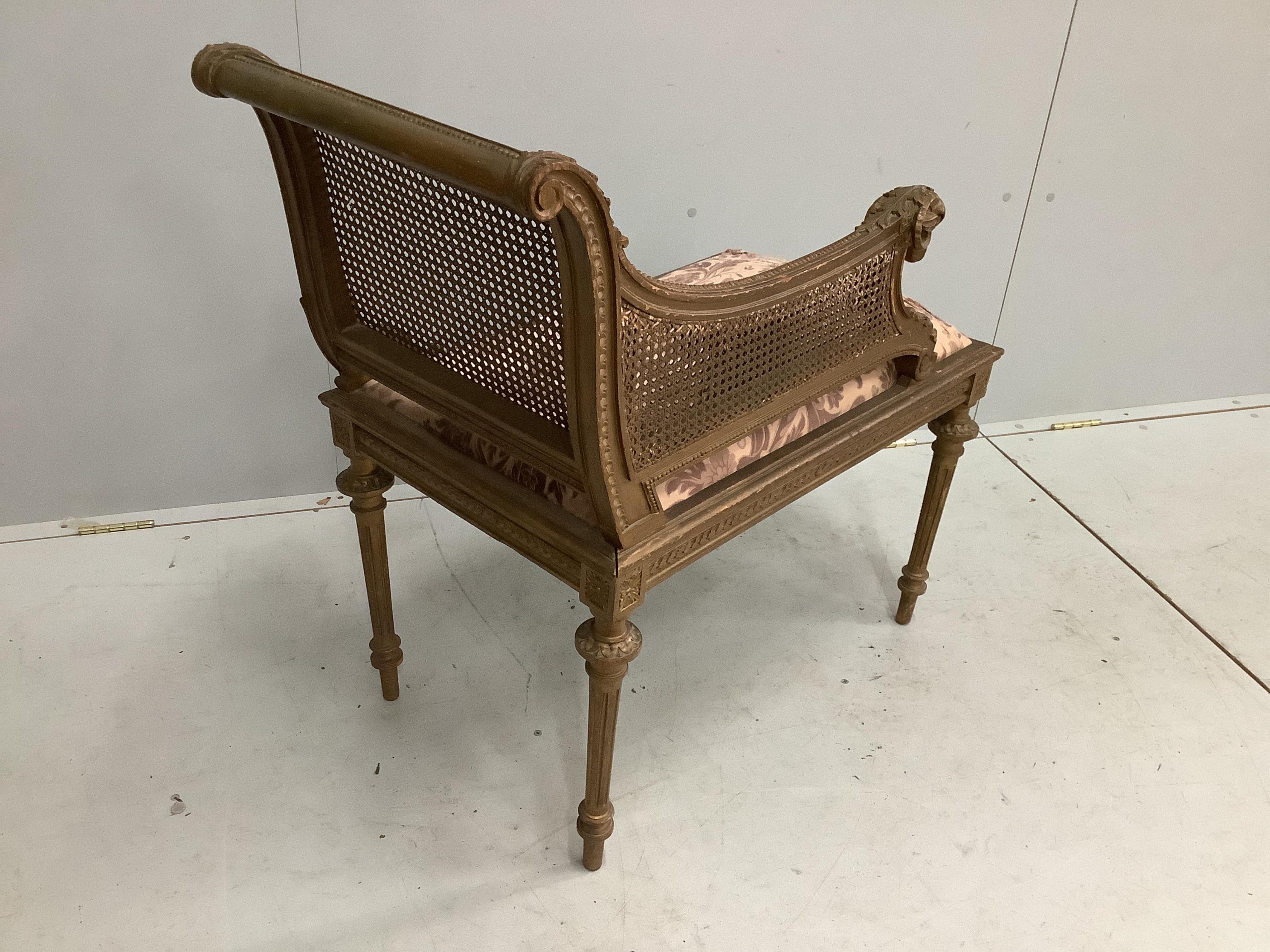 A Louis XVI style painted and giltwood caned seat, width 75cm, depth 44cm, height 84cm. Condition - fair